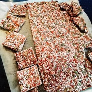 A layer of seeds n rice syrup baked until crunchy and golden on parchment paper and broken into squares and edges crumbled